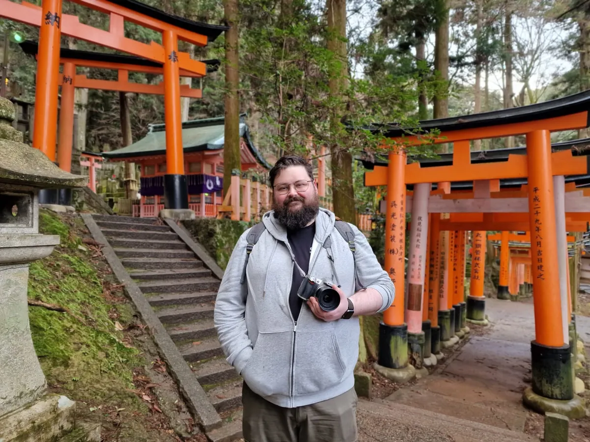 伏見稲荷大社の鳥居の前に立っている私、周りに人はいない。